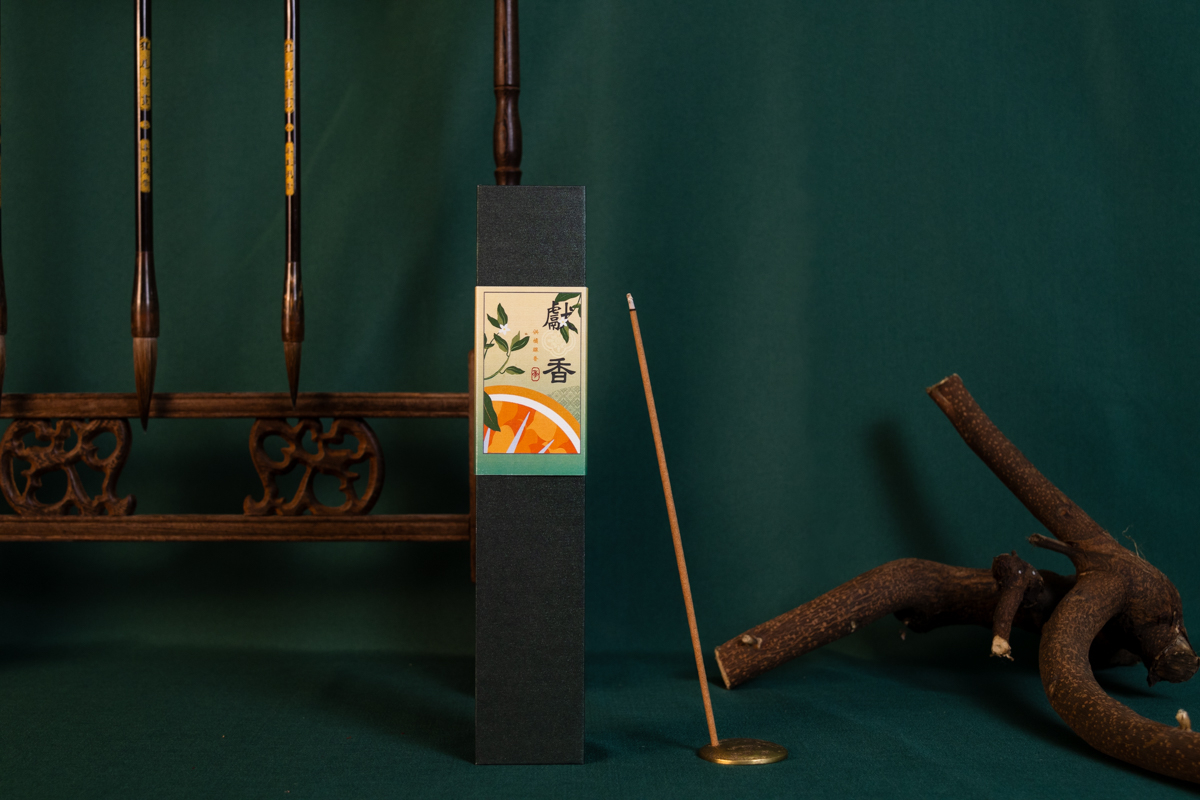 A black box with a stick on it next to a wooden spoonDescription automatically generated